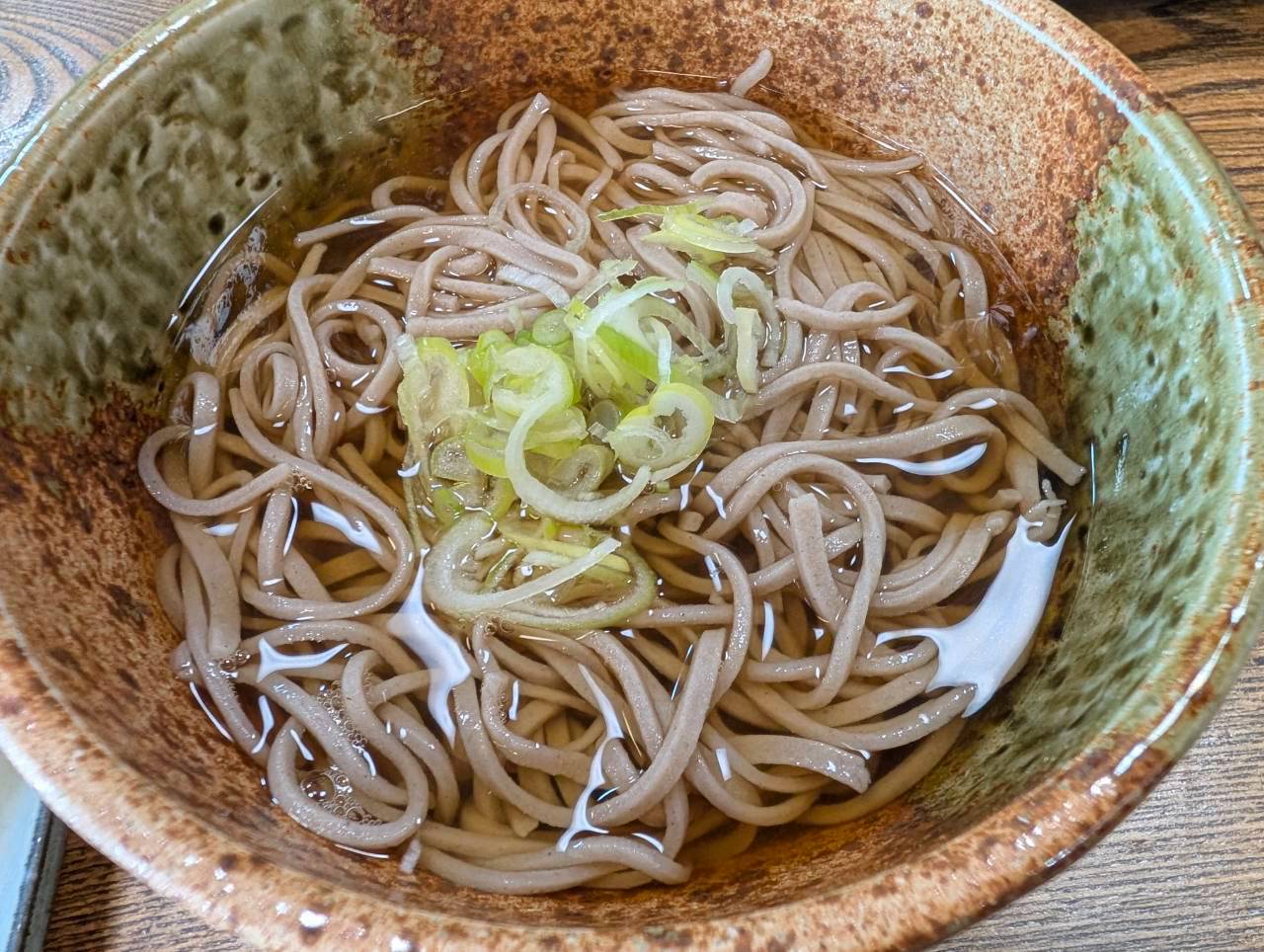 つゆを張った器に盛られたもろはくやの手打ちそば