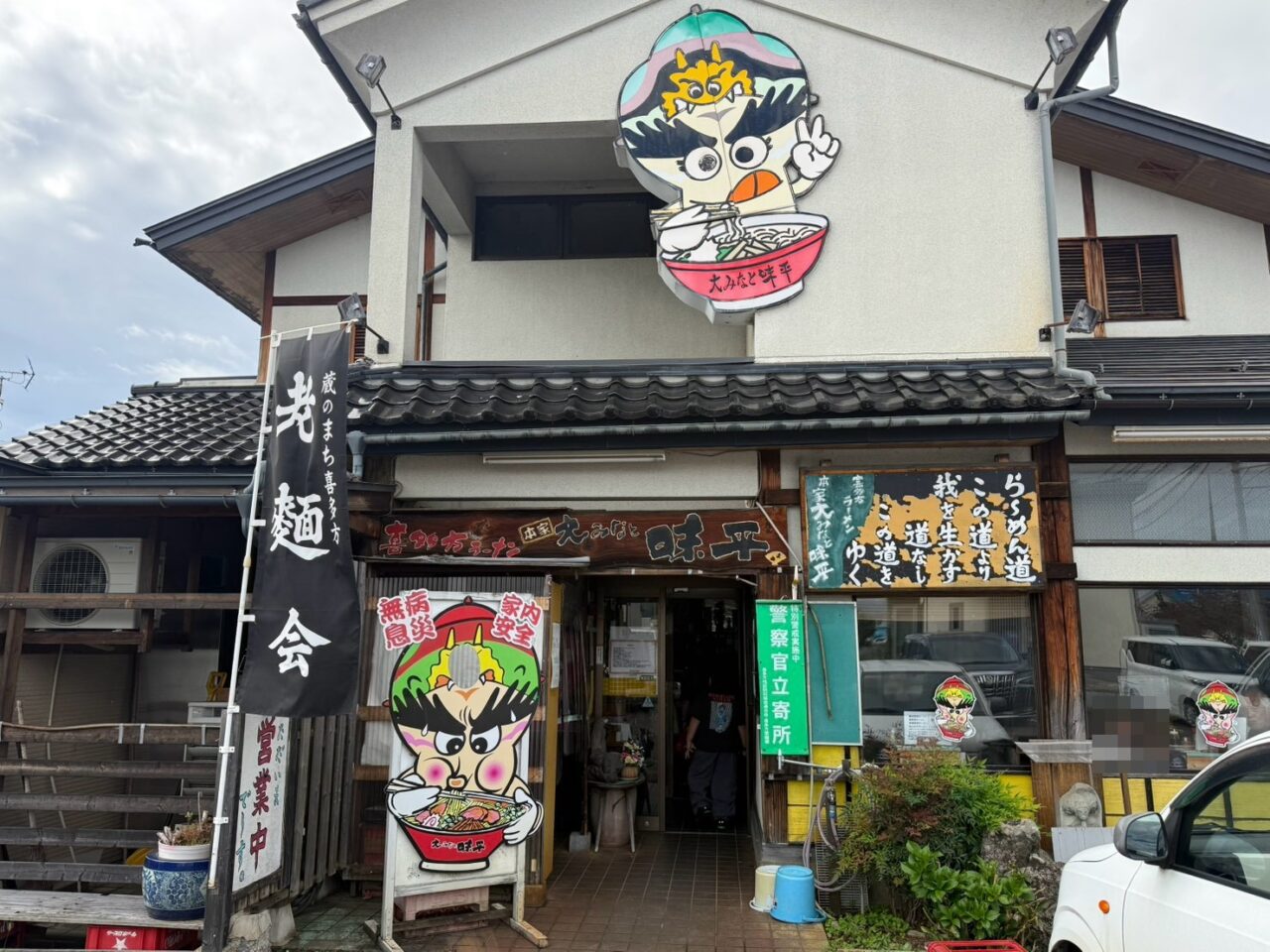 本家大みなと味平の入口とラーメンを食べるキャラクターの看板