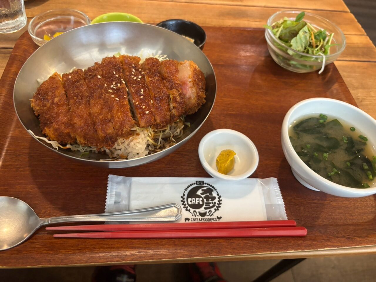 CAFEオヤジのソースカツ丼。キャベツの上にカツがのり、サラダとスープが付いている