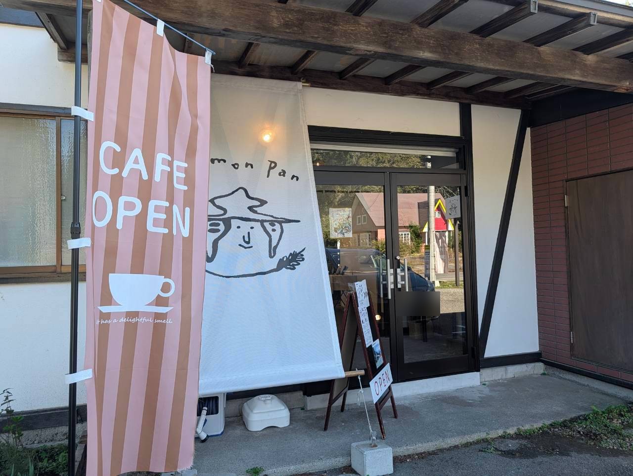ドモンパンの入口。CAFE OPENののぼりとロゴ入りの大きな布
