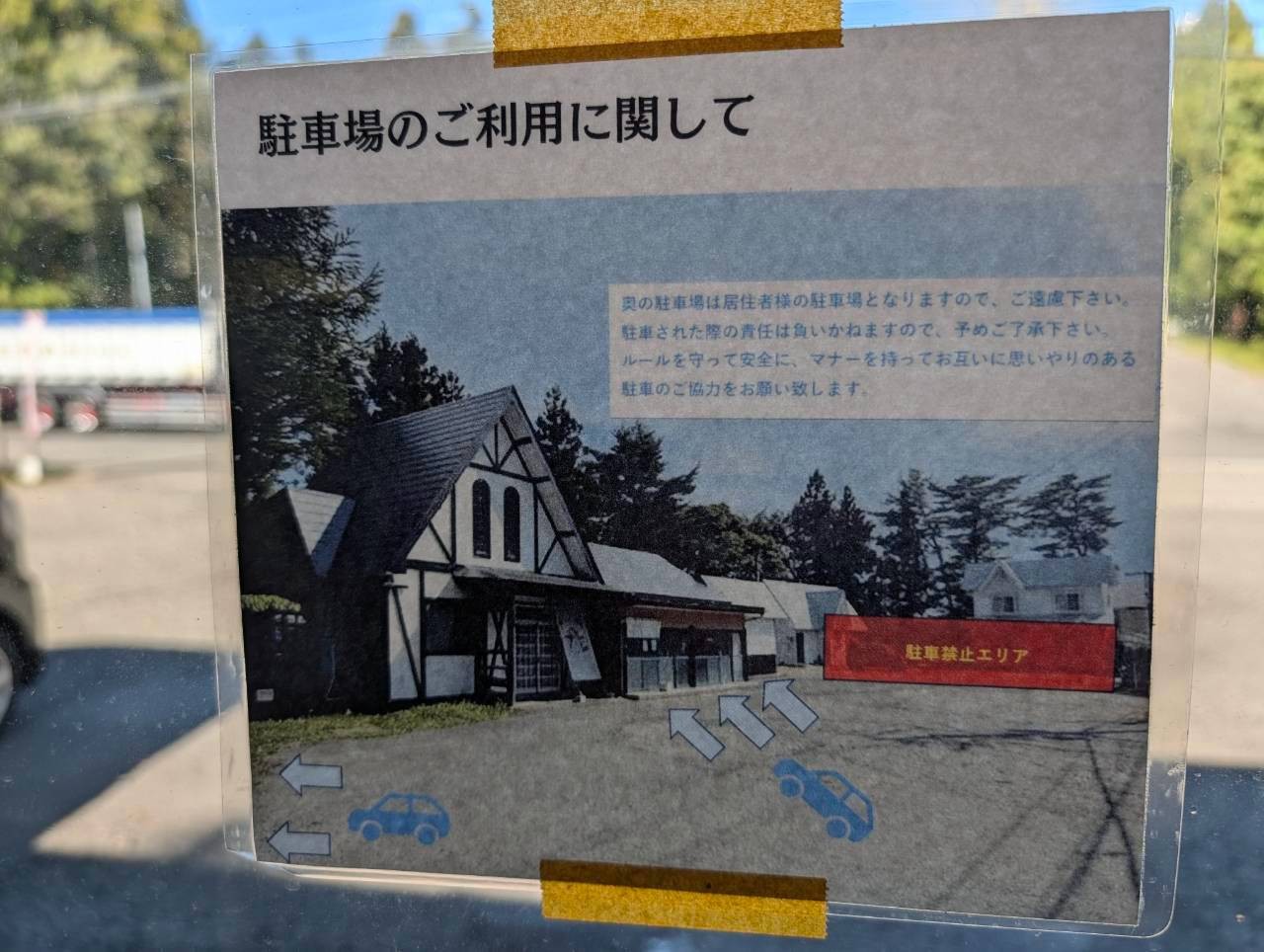 店頭に掲示された駐車場の利用案内。奥の駐車場は居住者用