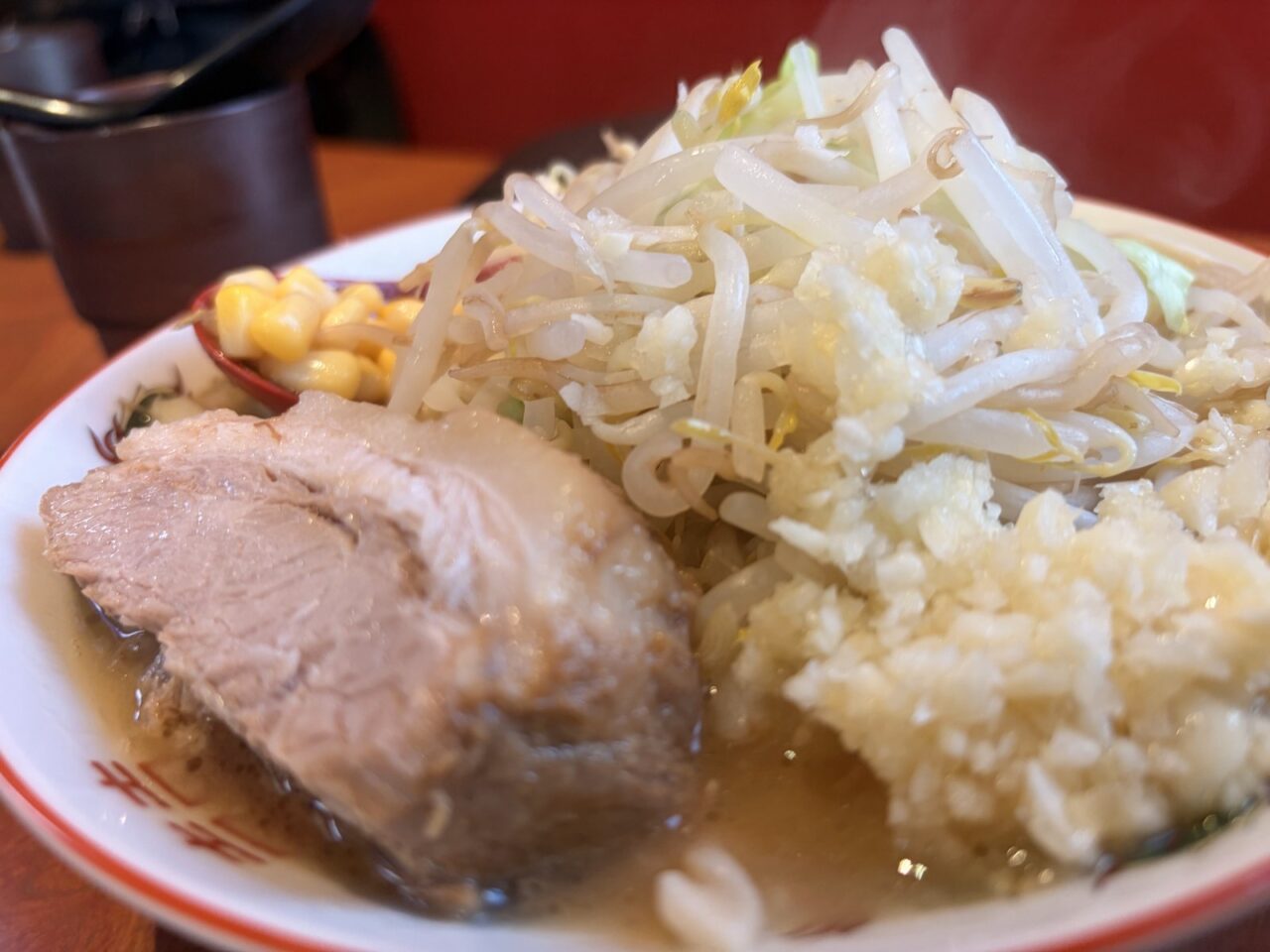 ミニラーメンの厚切りの豚とレンゲに入ったコーンのアップ