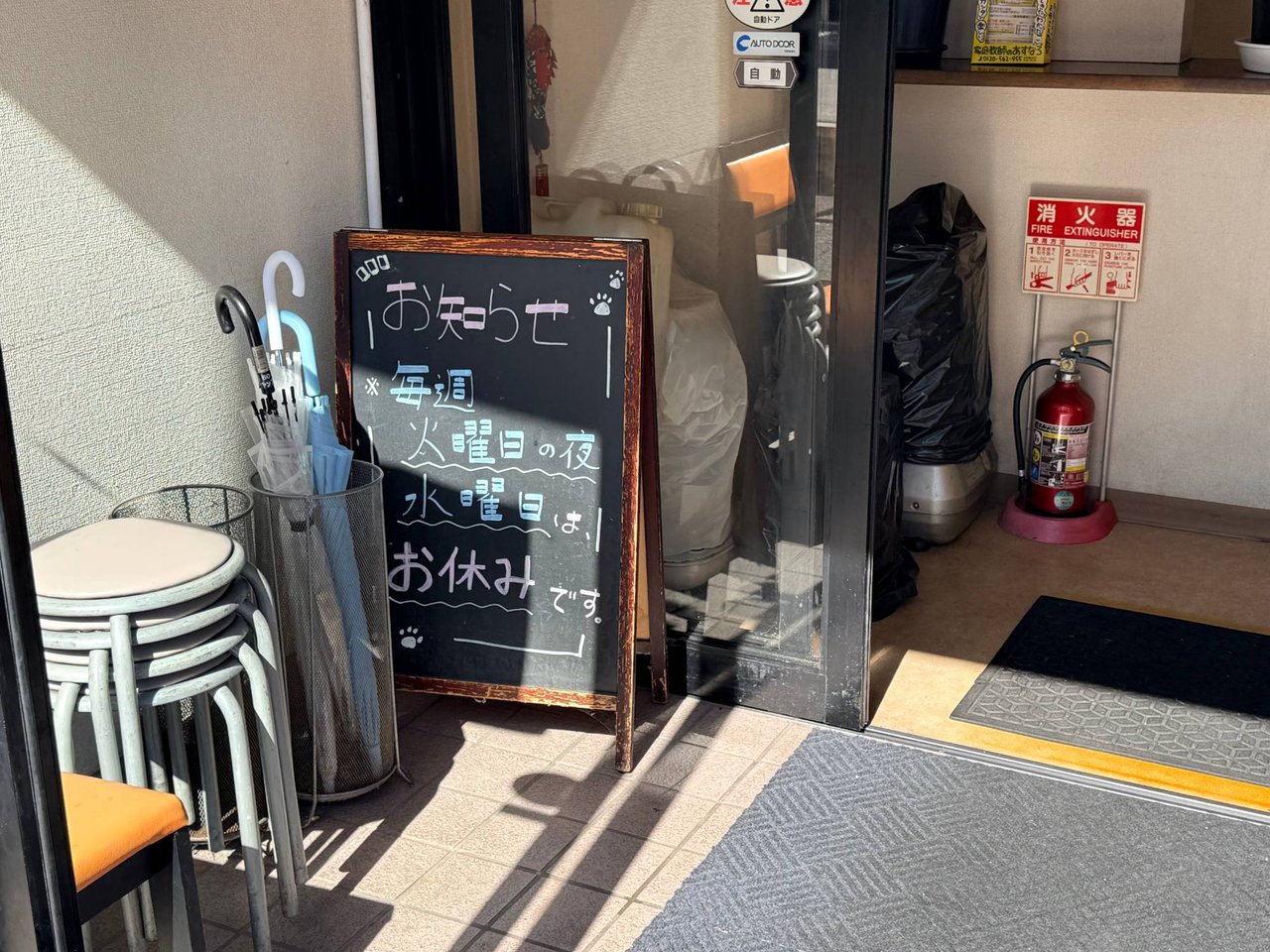 毎週火曜日の夜と水曜日は休みと書かれた入口の黒板