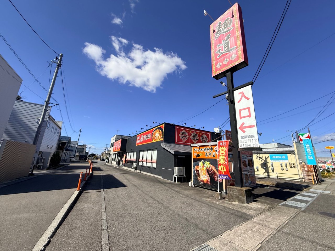 道路沿いに立つ「麺道 菜華楼」のポール看板と店舗外観