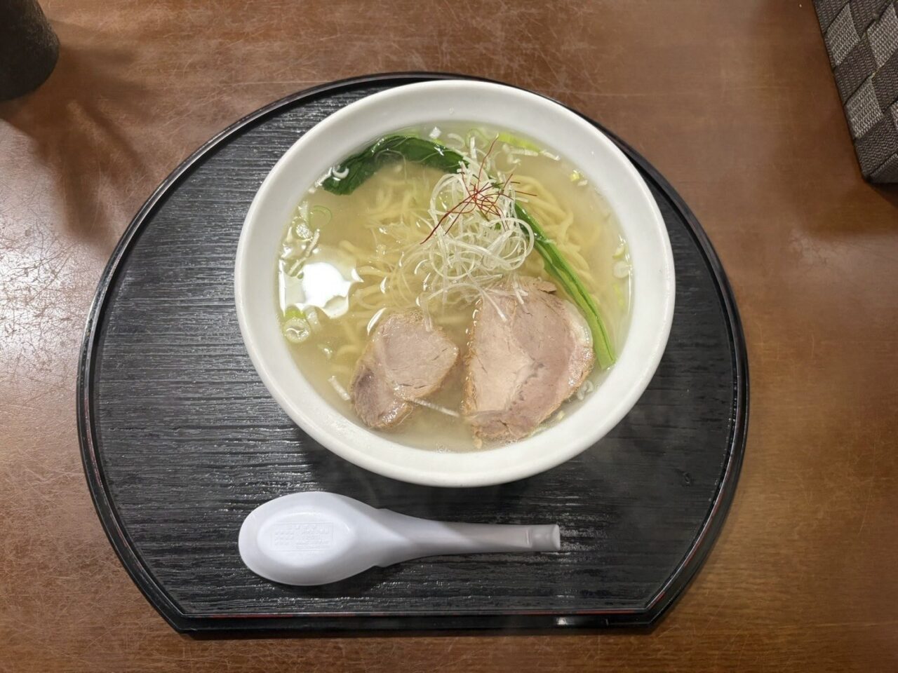 透き通ったスープにチャーシューと青菜、白髪ねぎがのった塩川屋の塩ラーメン