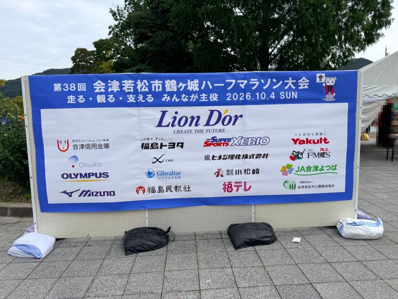 第38回会津若松市鶴ヶ城ハーフマラソン大会の名称と協賛各社のロゴが入った会場の横断幕