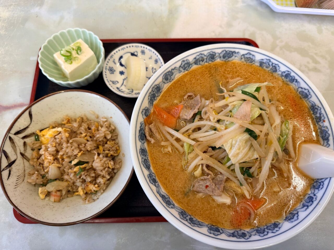 舎食堂のミソラーメンと半チャーハン、豆腐の小鉢とお新香がのったお盆